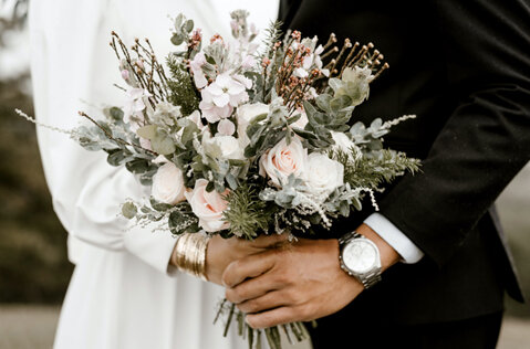 A bride and groom with a flower bouquet